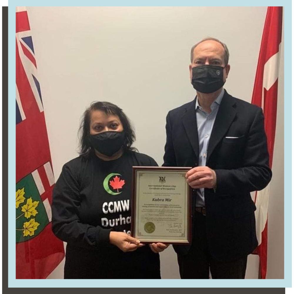 Kubra Mir accepts the 2022 International Women’s Day Award from The Honourable Peter Bethlenfalvy, Ontario Minister of Finance and MPP for Pickering-Uxbridge.